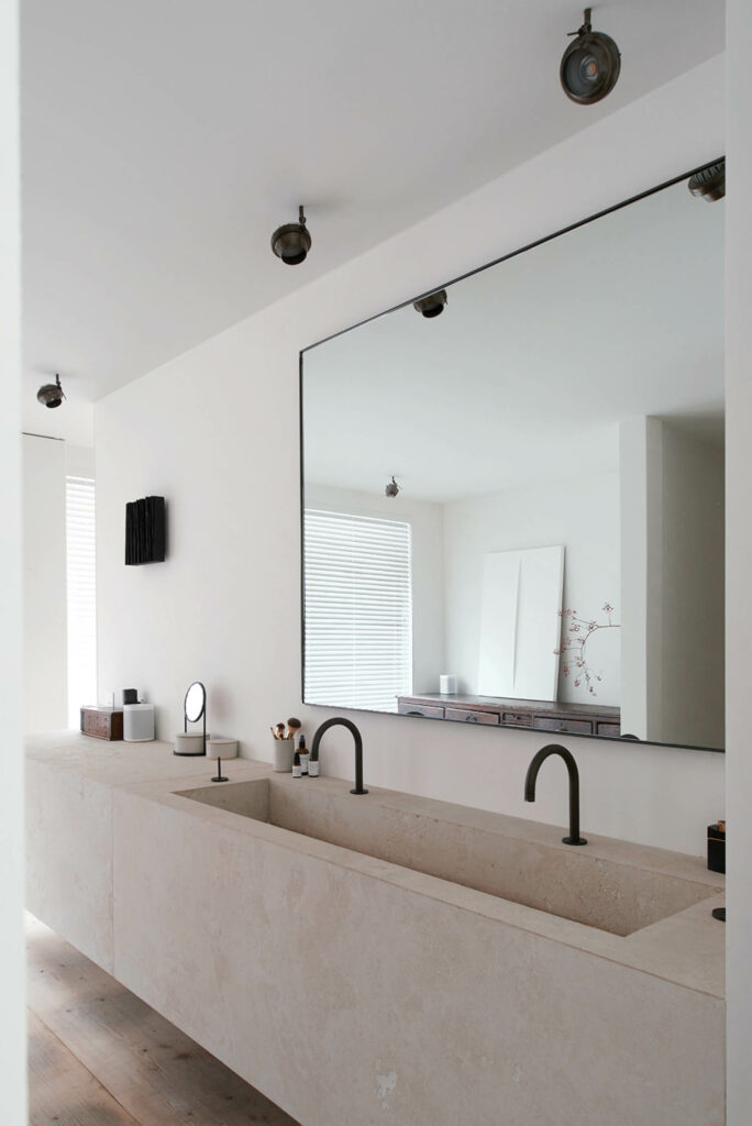 a limestone vanity in the main bathroom of a Belgian home